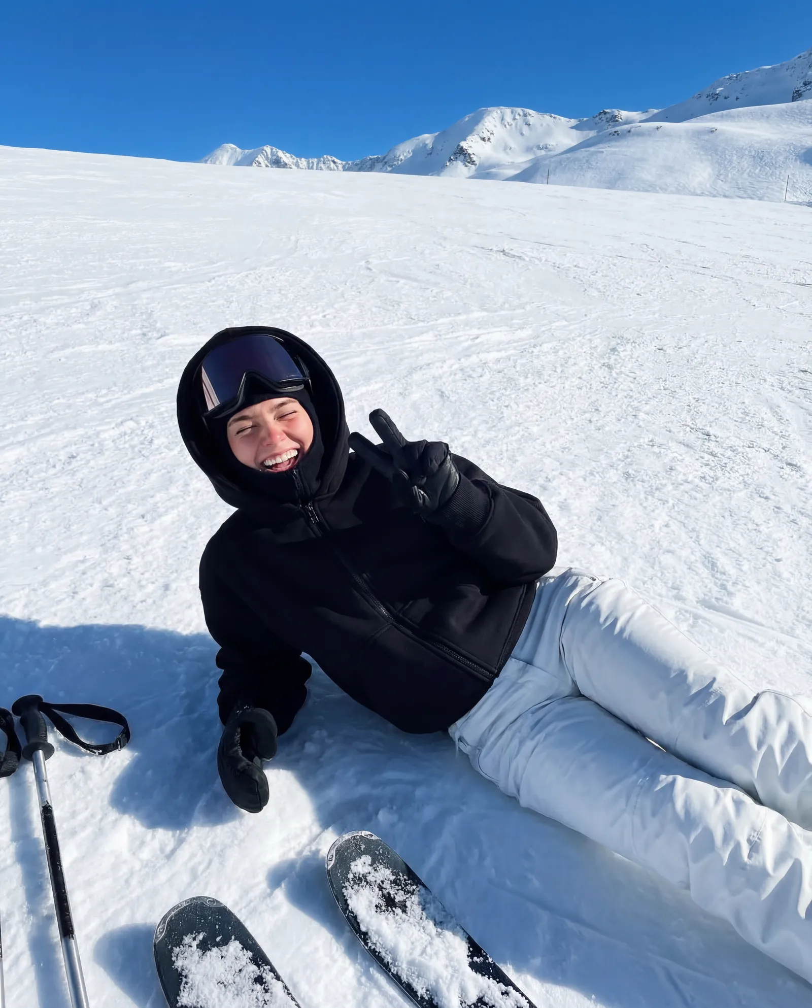 Райдер FROZENCREW сидит на снегу, за спиной панорама горного хребта