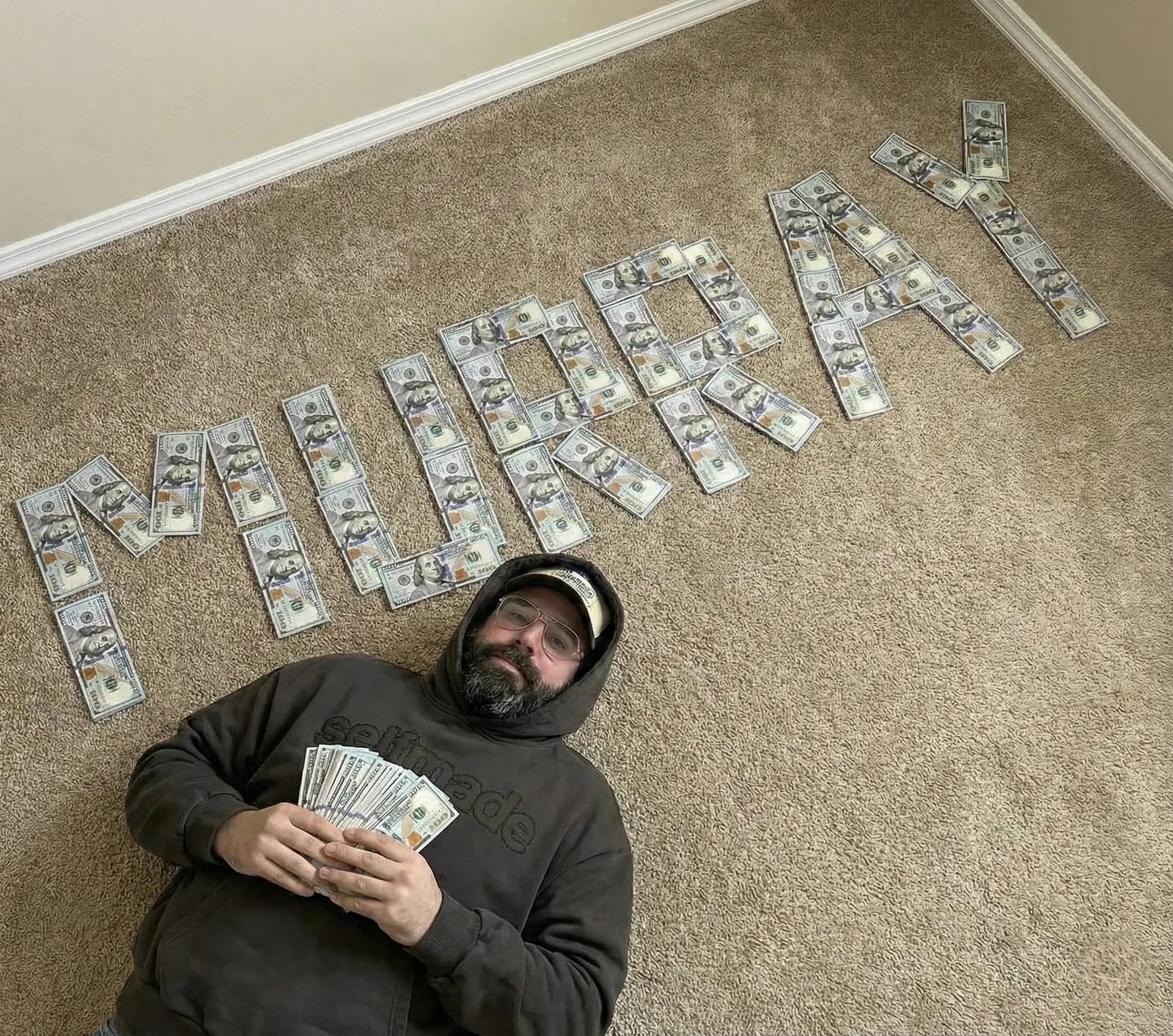 Надпись из купюр и модель в тёмном худи pullupclub с банкнотами в руках
